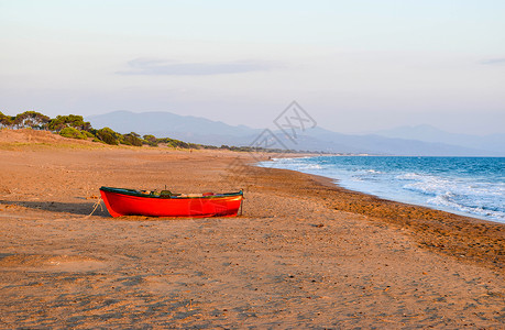 日落时分希腊凯法斯荒凉沙滩上的小船图片