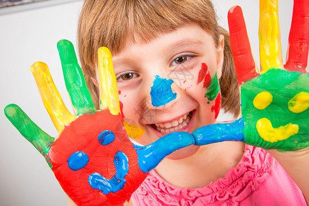 微笑的小女孩双手涂着五颜六色的颜料图片