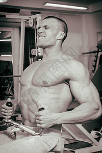 肌肉男健美运动员在健身房训练和摆肌肉图片