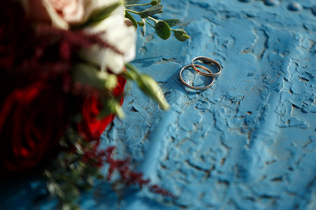 蓝色背景上的红玫瑰婚礼花束图片