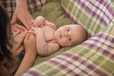 母亲和父亲节的概念手放在婴儿上刚出生的婴儿躺在扶手椅上家庭图片