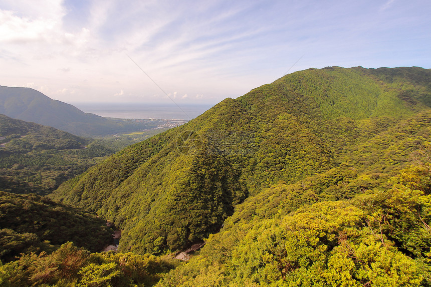 从通往日本ShirataniUnsuikyoRavine公园的公路上看到北面大片绿山和雅库岛海滨图片