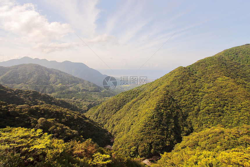 从通往日本ShirataniUnsuikyoRavine公园的公路上看到北面大片绿山和雅库岛海滨图片