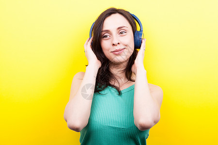 有趣的女孩在演播室用黄色背景的耳图片