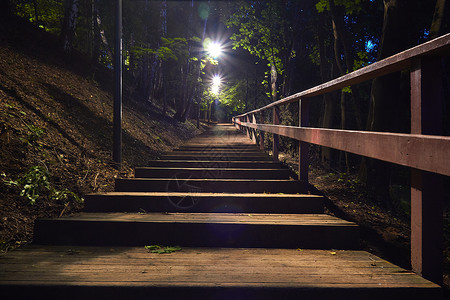 晚上在树林里的木楼梯用灯笼照明图片