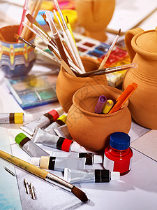正宗的画笔静物在艺术课学校的桌子上作为绘画课程粘土罐中的刷子组艺图片