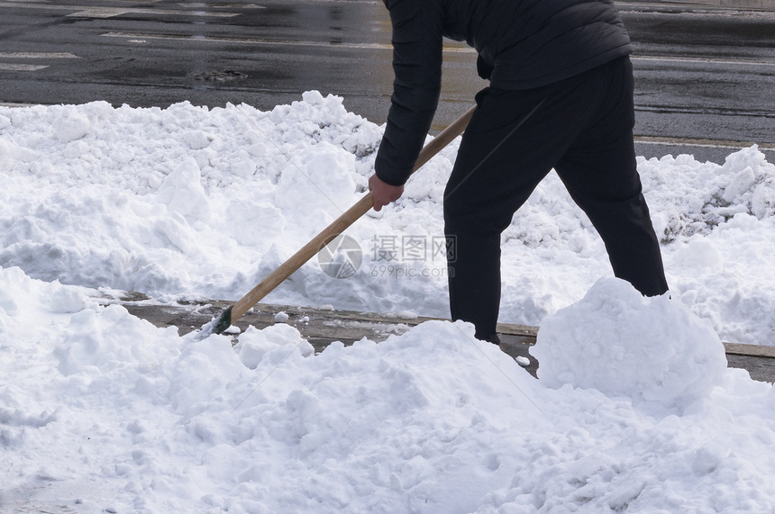 在大雪降后用铲子清理雪一个人在城图片