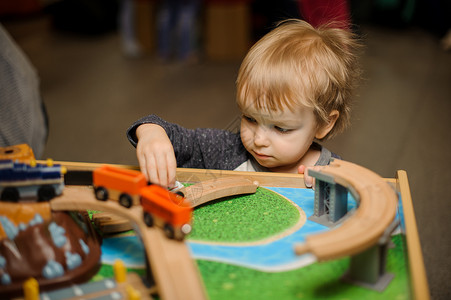 可爱的小男孩在玩具木制火车在游戏图片