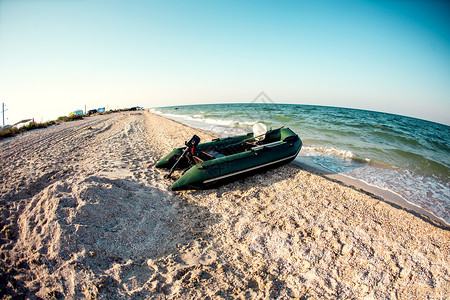 沙滩上的充气船海岸海边美丽的日落图片