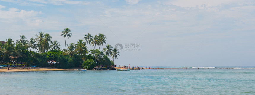 海浪映衬着蓝天和棕榈树图片