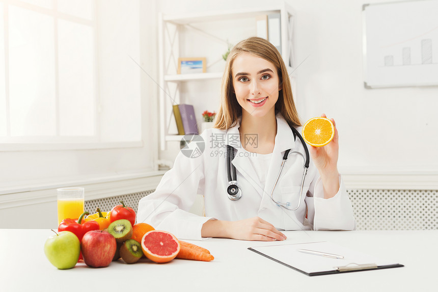 营养师拿着新鲜的橙子女营养师拿着水果正确饮食营养健康食品减图片