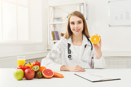 营养师拿着新鲜的橙子女营养师拿着水果正确饮食营养健康食品减图片