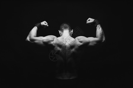 无法辨认的人体健美建筑师表现出强壮的手和背部肌肉运动斗兽座黑白图像复制空间低键制片背景