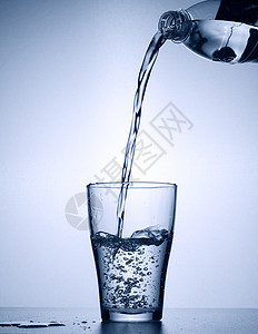 淡水从瓶中倒入玻璃杯中图片