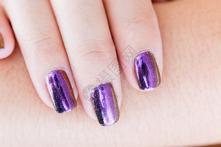手握着美丽的指甲油紫色指甲修指图片