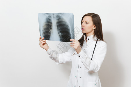 困惑的集中医生女人与肺部X射线荧光造影伦琴隔离在白色背景上穿着医用长袍听诊器的女医生医护人员背景图片