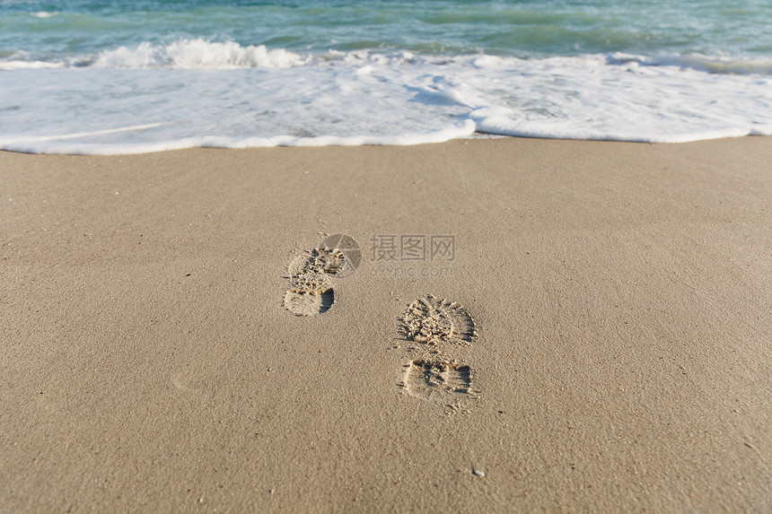 一个人的脚印被贴在沙滩上图片