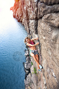 女孩从事运动攀岩登山者爬上岩石图片