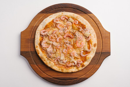 在木制比萨盘上供应番茄酱奶酪虾鸡肉火腿和菠萝的比萨顶视图图片