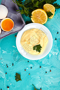 自制酱蛋黄酱和配料鸡蛋油柠檬芥末酱在蓝色背景顶级竞争图片