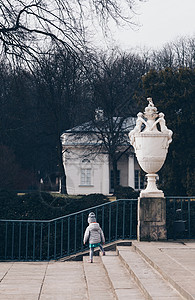 在波兰华沙Lazienki公园的皇家宫殿里单独玩耍的儿童图片
