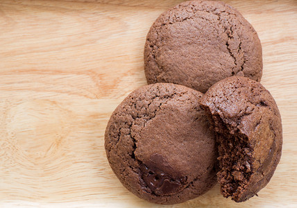 木板上放着自制的软巧克力黑巧克力蛋糕饼干闭合饼干被咬了图片