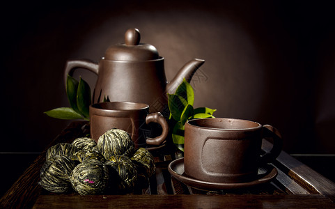 棕色背景中粘土茶壶和杯子的静物背景图片