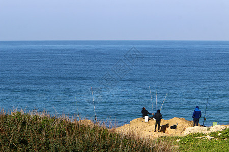 渔夫坐在岸边抓鱼图片