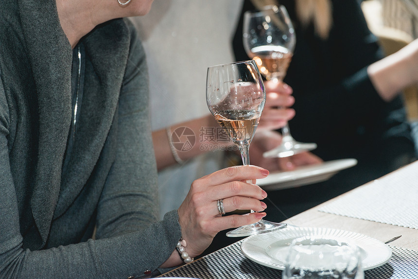 女人拿着一杯红酒品酒时桌上的眼镜人们会考虑葡萄酒的颜色并尝试在不同的玻璃杯中图片
