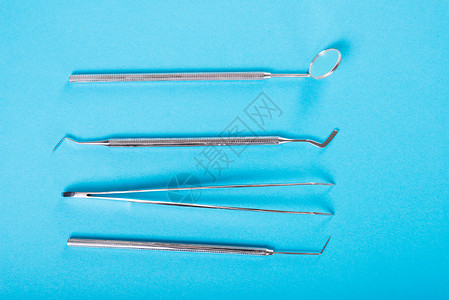 蓝色背景上四个工具的牙科套装图片