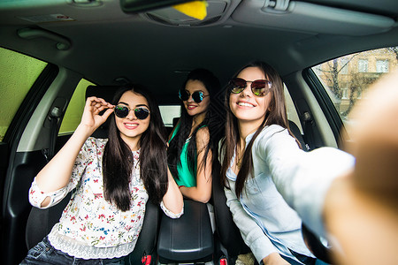 三个女孩在车里玩得开心拿图片