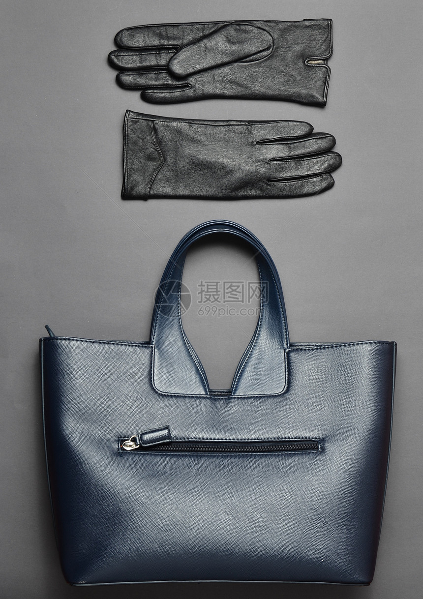 蓝色皮包和灰色背景的手套图片