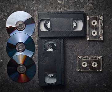 黑色混凝土表面上的平躺录像带CD录音带过去的复古媒体图片