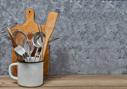 用于在混凝土墙背景的木桌上烹饪的厨房工具复制空间勺子背景图片