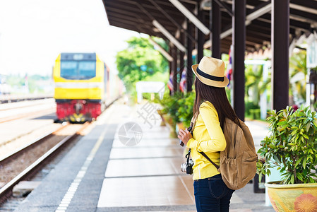 独自步行的女旅行者携带行李和在车站等候图片
