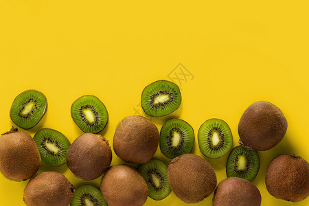 黄色背景上的新鲜水果切猕猴桃和猕猴桃图片