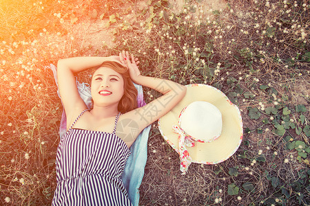 年轻感女人的顶部风景躺在草地上紧贴帽子的青草图片