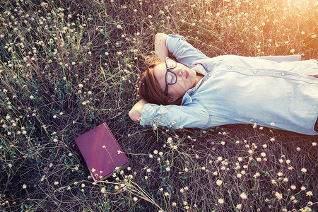 美丽的年轻嬉皮士躺在草地图片
