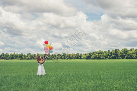 在草地上拿着气球的年轻美人享受新鲜空气吧图片