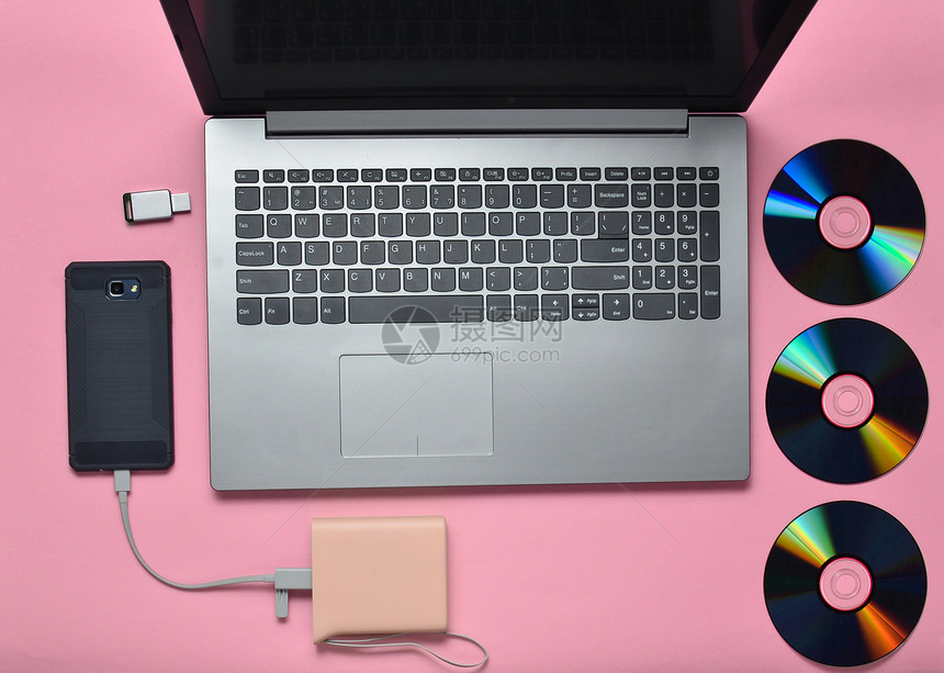 笔记本电脑智能手机电库CD驱动器粉红色背景的USB闪存盘现代和过时的数图片