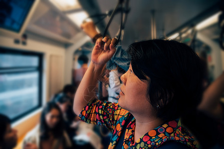 亚洲女在城市乘坐天际列车旅行图片