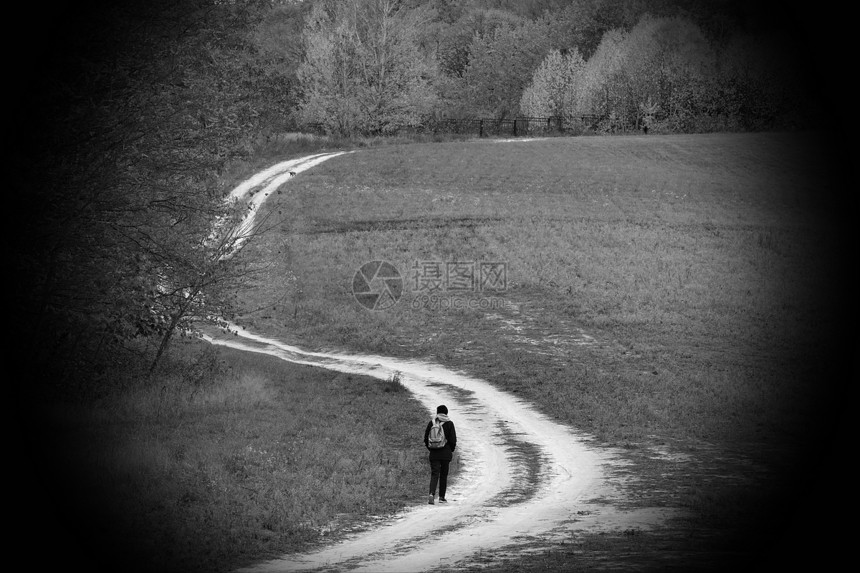 孤独的旅行者蜿蜒的乡间小路通向秋天的森林背着包背面秋天森林的人从概念上讲分离漫长的道路旅行工图片