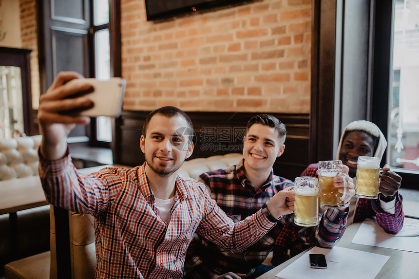 快乐的老朋友在酒吧里玩自拍和喝啤图片