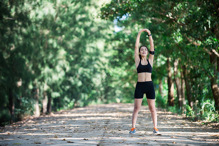 年轻的健身女人在跑步前伸展双腿图片
