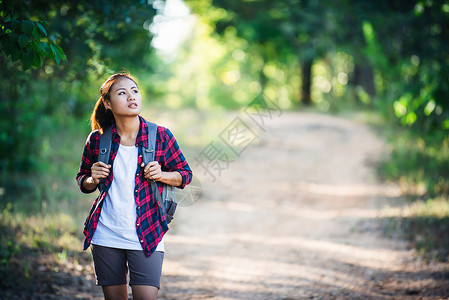 年轻女子徒步旅行者背着包走动图片