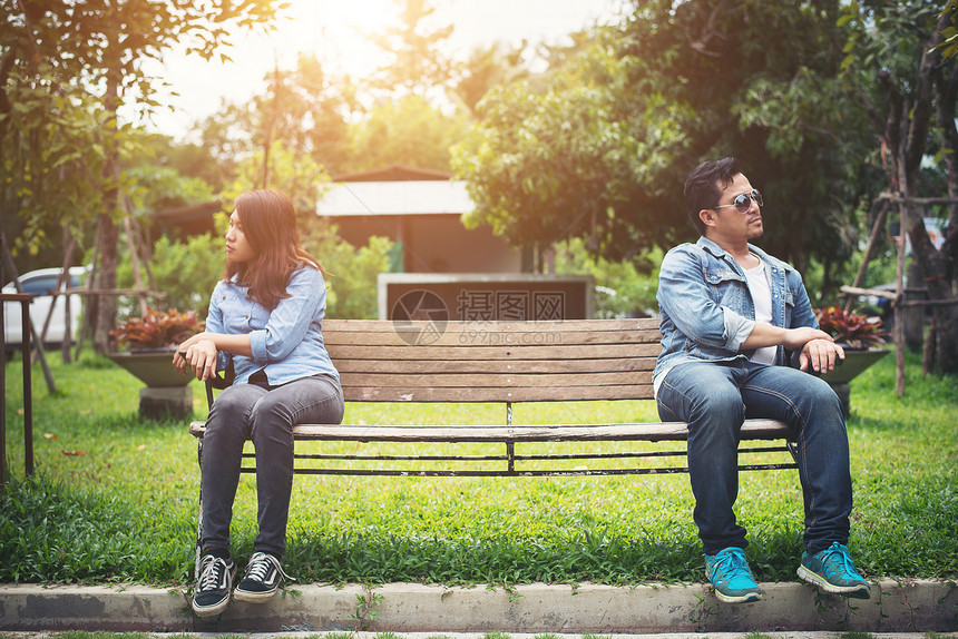坐在公园的长椅上不开心的年轻夫妇情侣生图片