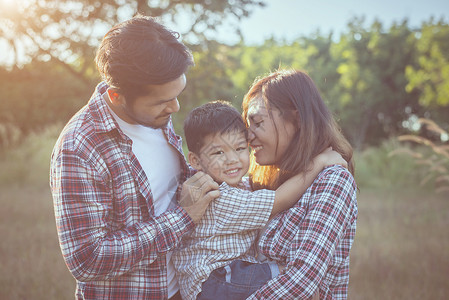 快乐的年轻家庭在绿色自然公园外面共度时光家庭爱的概念图片