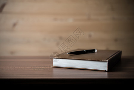用笔在木桌上的书图片