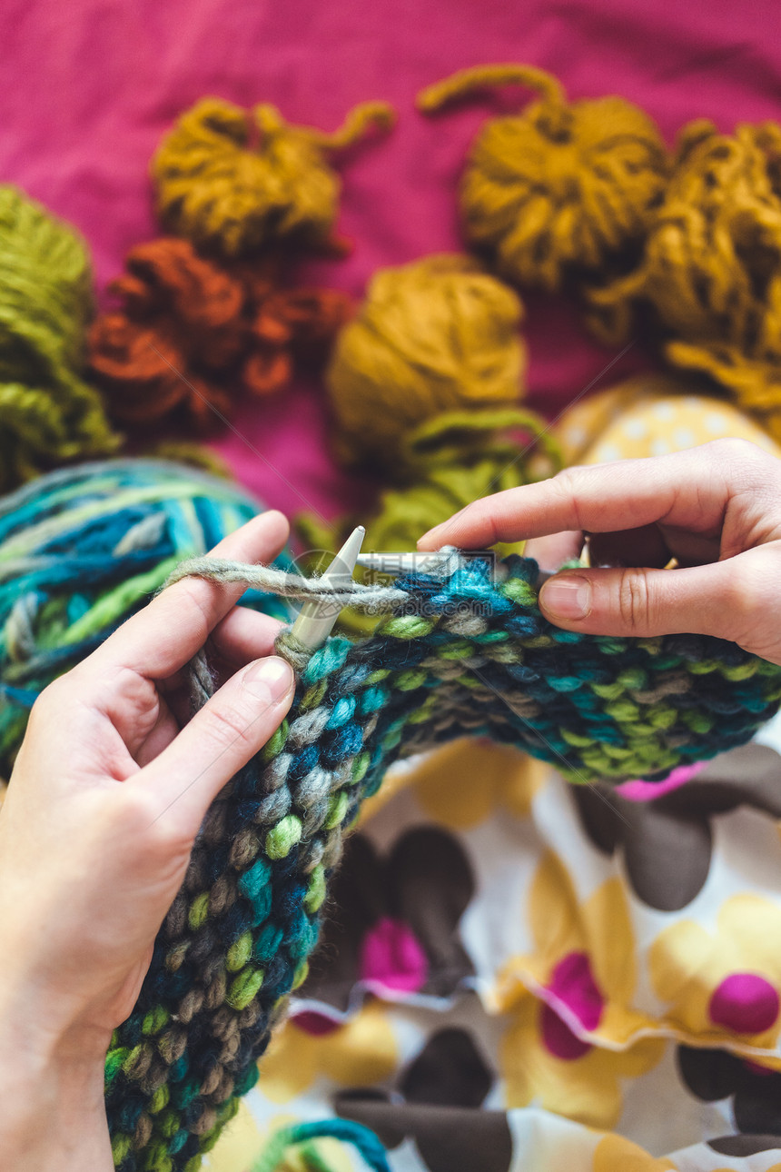 女人编织用织针编织羊毛线管多色线程这个女孩从事手工制图片