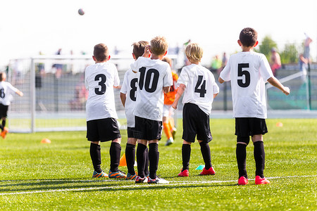 儿童足球队观看足球比赛的年轻男孩背景中的足球锦标赛比足球场上的儿图片